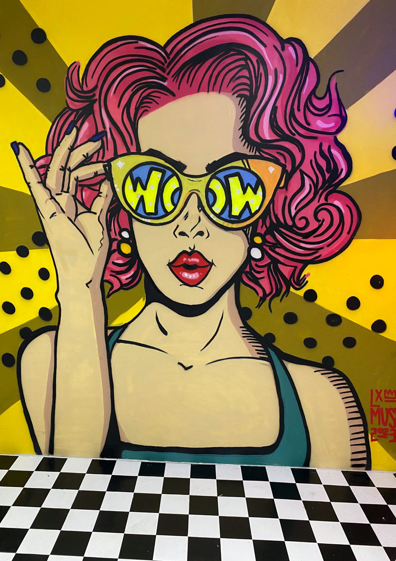 Graffiti von Frau mit Sonnenbrille und pinken Haaren